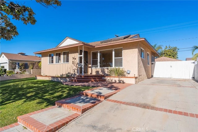 ranch-style home featuring a front yard and solar panels