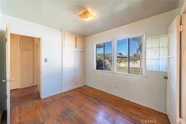 unfurnished bedroom featuring a closet and dark hardwood / wood-style floors