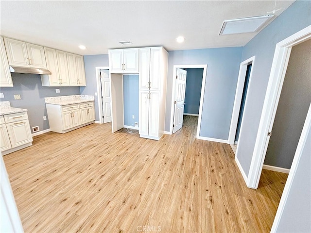 kitchen with light stone counters and light wood-type flooring