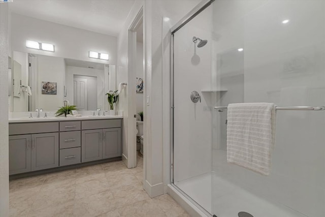 bathroom with toilet, a shower with shower door, and vanity