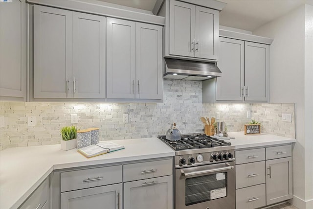 kitchen featuring decorative backsplash, high end range, and gray cabinets