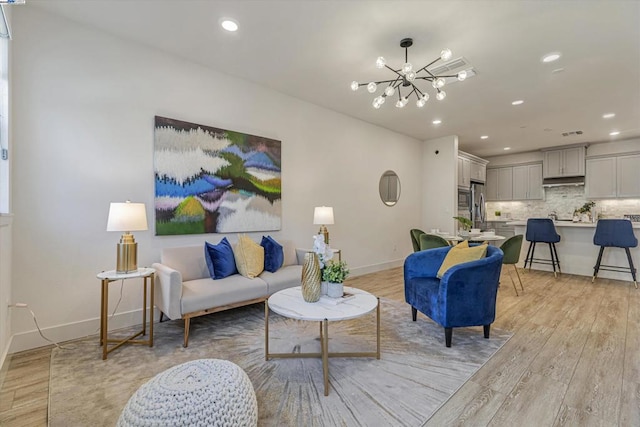 living room featuring light wood-type flooring and a chandelier