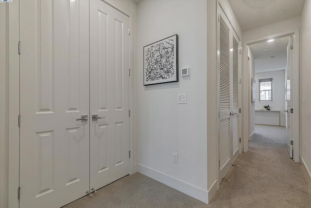 hall with light colored carpet