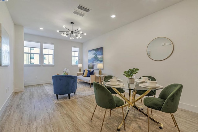 dining area featuring light wood-type flooring and a chandelier