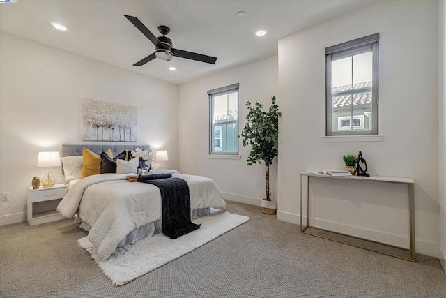 bedroom featuring multiple windows, light colored carpet, and ceiling fan