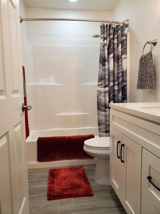 full bathroom featuring toilet, shower / tub combo, hardwood / wood-style floors, and vanity