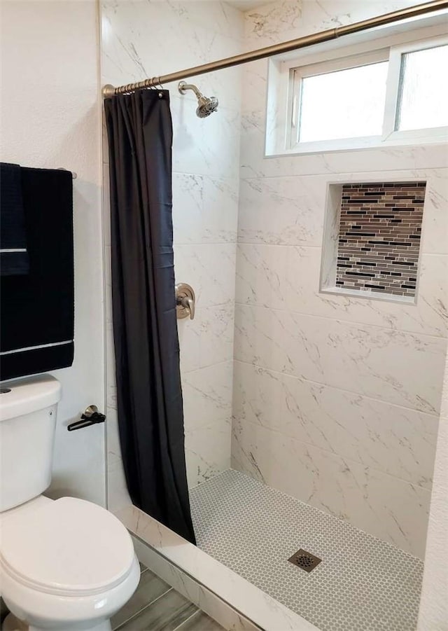 bathroom featuring toilet, a shower with curtain, and hardwood / wood-style flooring