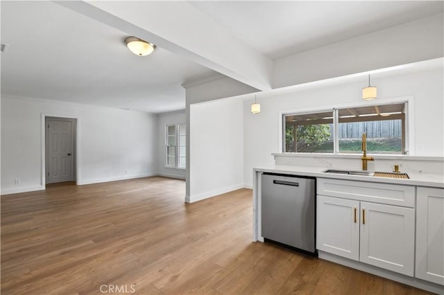 kitchen featuring decorative light fixtures, dishwasher, sink, and white cabinetry