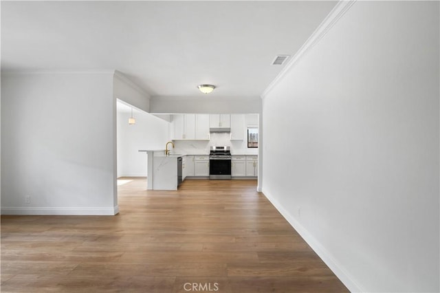 interior space with crown molding, white cabinets, stainless steel appliances, and light wood-type flooring