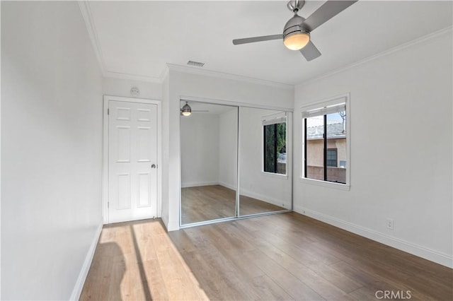 unfurnished bedroom featuring ceiling fan, light hardwood / wood-style floors, a closet, and ornamental molding