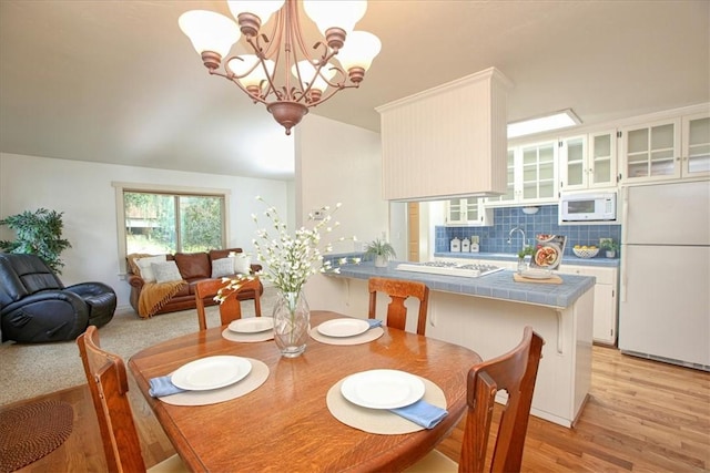 dining area with a chandelier, light hardwood / wood-style floors, and sink