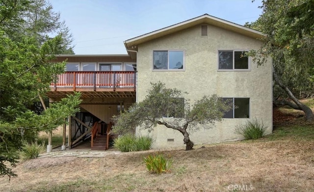 rear view of house featuring a wooden deck