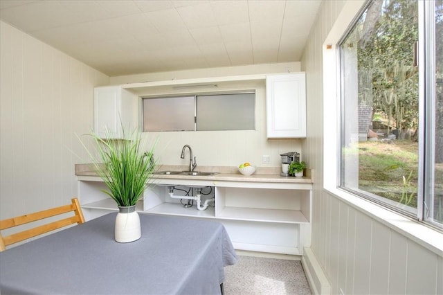 kitchen featuring built in desk, white cabinets, sink, and a wealth of natural light