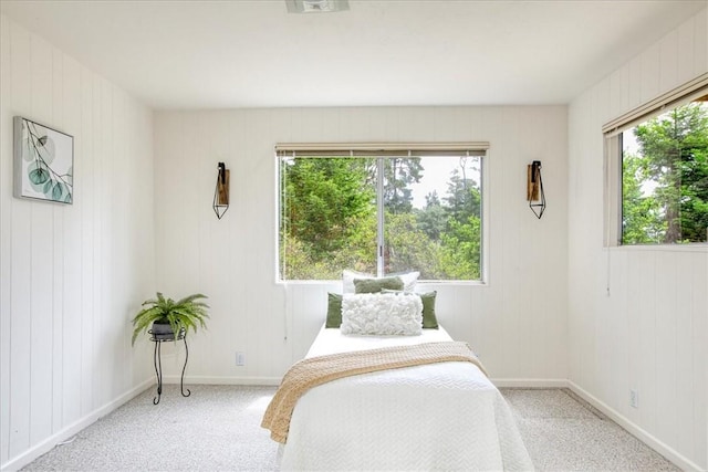 bedroom featuring light carpet and multiple windows