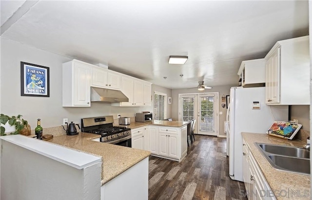 kitchen featuring kitchen peninsula, appliances with stainless steel finishes, dark hardwood / wood-style floors, white cabinets, and sink