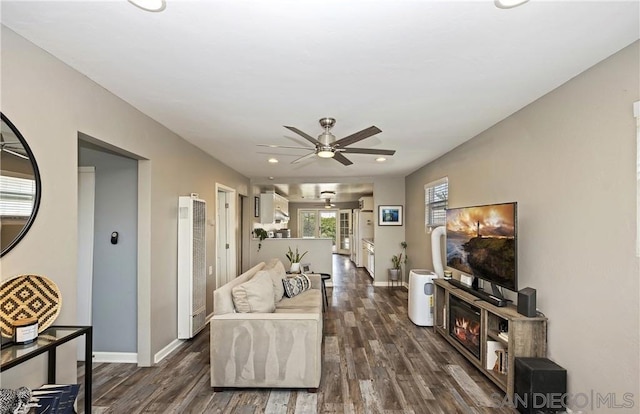 living room featuring ceiling fan and dark wood-type flooring