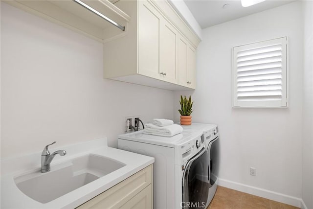 laundry room featuring cabinets, light tile patterned floors, washer and clothes dryer, and sink