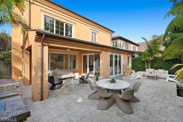 rear view of house with french doors, outdoor lounge area, and a patio