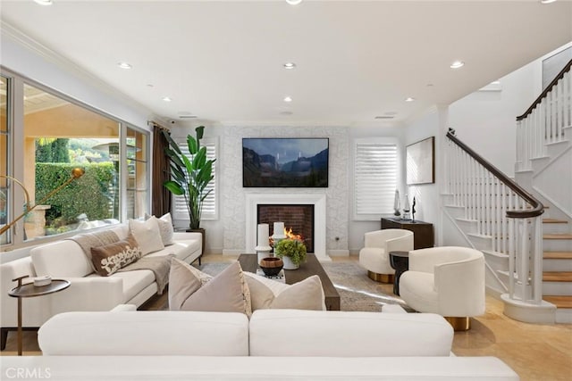 living room featuring a large fireplace and crown molding