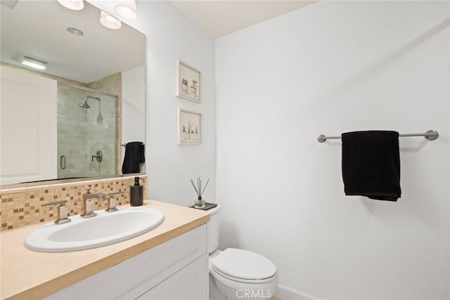 bathroom featuring a shower with shower door, vanity, decorative backsplash, and toilet