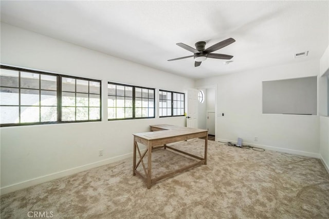 carpeted office space featuring ceiling fan