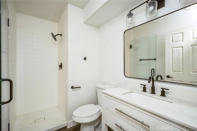 bathroom with vanity, tiled shower, and toilet