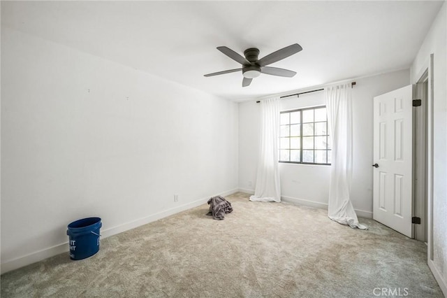 empty room featuring ceiling fan and carpet