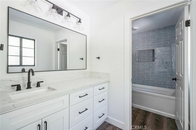 bathroom with tiled shower / bath combo, vanity, and hardwood / wood-style floors