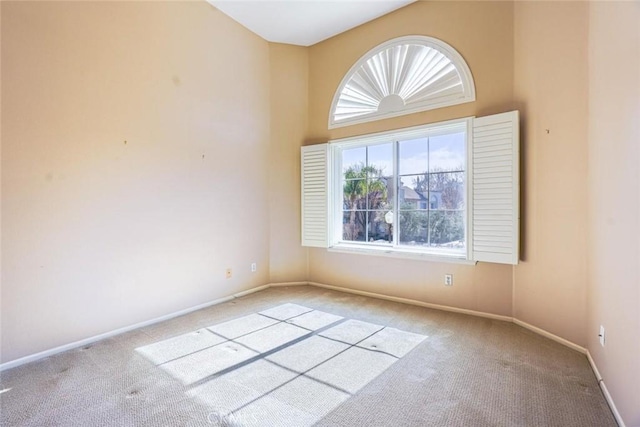 empty room with a towering ceiling and light colored carpet