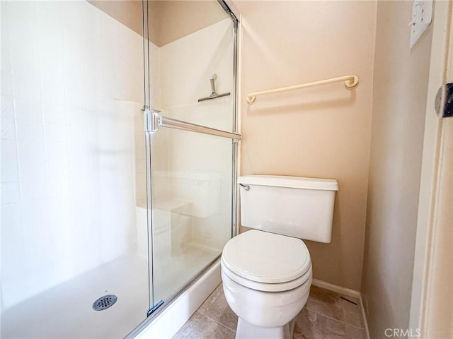 bathroom with a shower with door and toilet