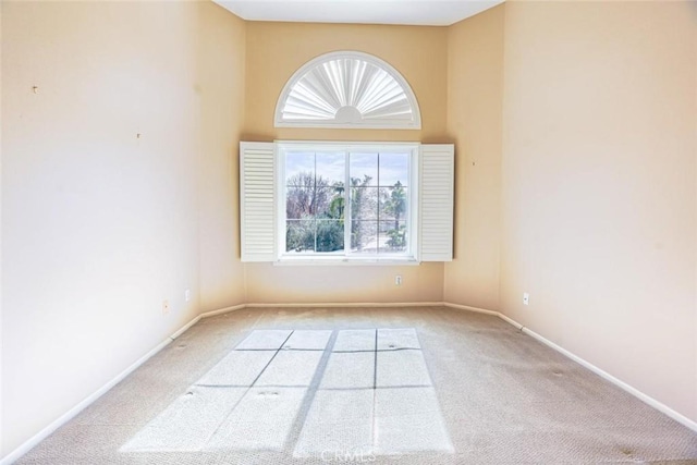 carpeted spare room with a towering ceiling