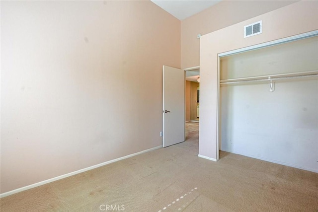 unfurnished bedroom with light carpet and a closet