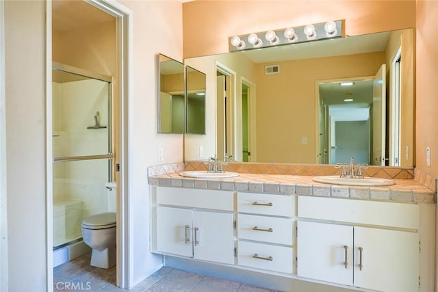 bathroom featuring vanity, toilet, and a shower with shower door