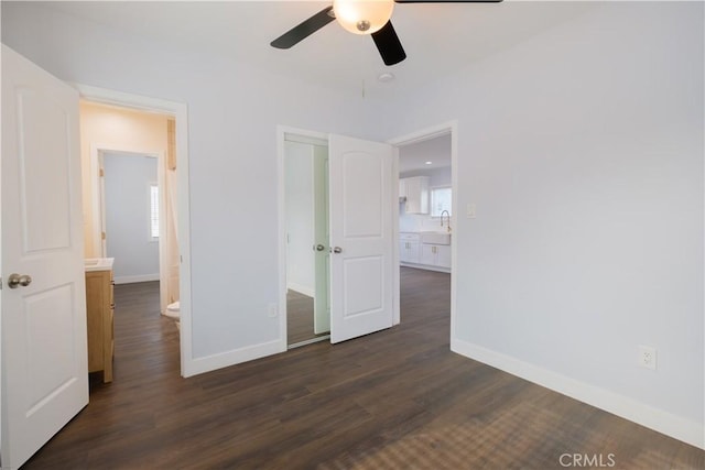 unfurnished bedroom featuring ceiling fan, dark hardwood / wood-style floors, sink, and ensuite bathroom