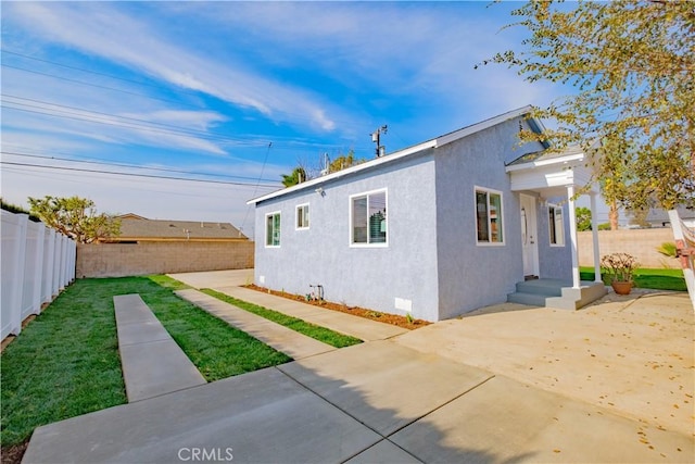 view of home's exterior with a patio area and a yard