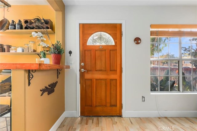 foyer entrance with a wealth of natural light and light hardwood / wood-style flooring