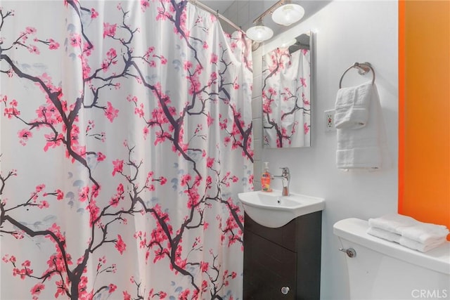 bathroom featuring toilet, a shower with curtain, and vanity