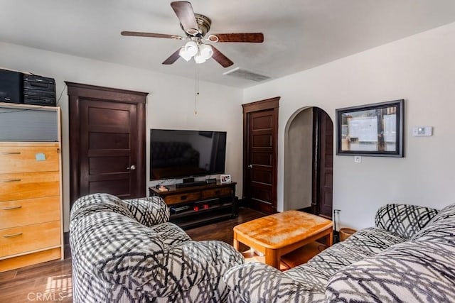 living room featuring ceiling fan and dark hardwood / wood-style floors