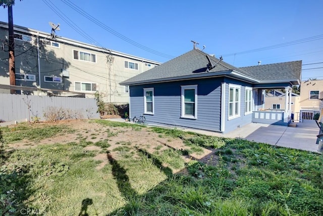 back of property with a patio area and a lawn