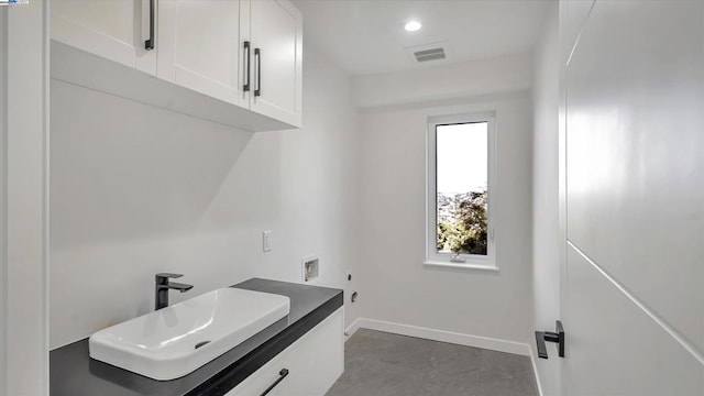 clothes washing area with hookup for an electric dryer, washer hookup, cabinets, gas dryer hookup, and sink