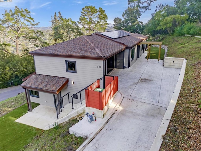 view of front facade with solar panels and a patio