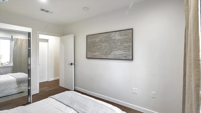 bedroom with dark hardwood / wood-style flooring