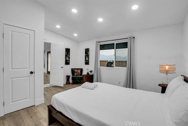 bedroom with vaulted ceiling and light hardwood / wood-style flooring