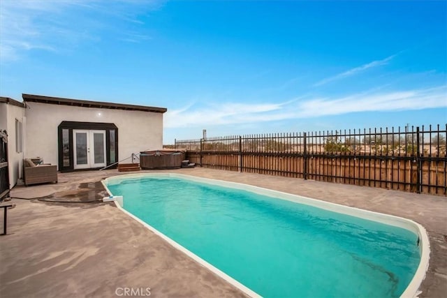 view of swimming pool featuring french doors, a patio area, and a hot tub