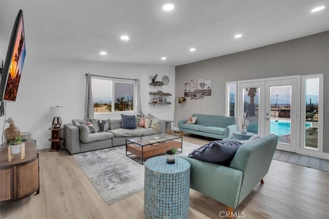 living room with french doors, plenty of natural light, and light hardwood / wood-style flooring