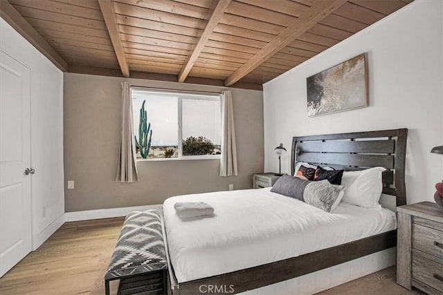 bedroom featuring light wood-type flooring, wooden ceiling, and beamed ceiling