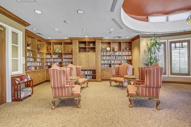 living area with light carpet, built in features, and crown molding