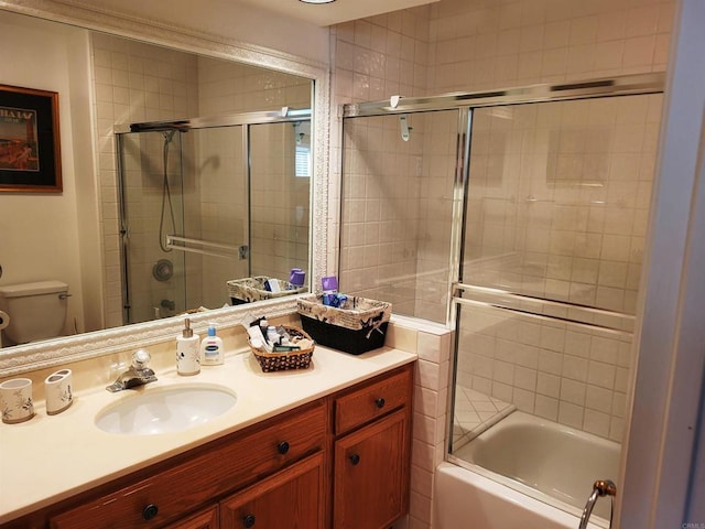 full bathroom with toilet, vanity, and shower / bath combination with glass door