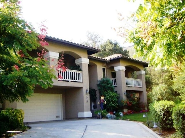 mediterranean / spanish-style home with a garage and a balcony