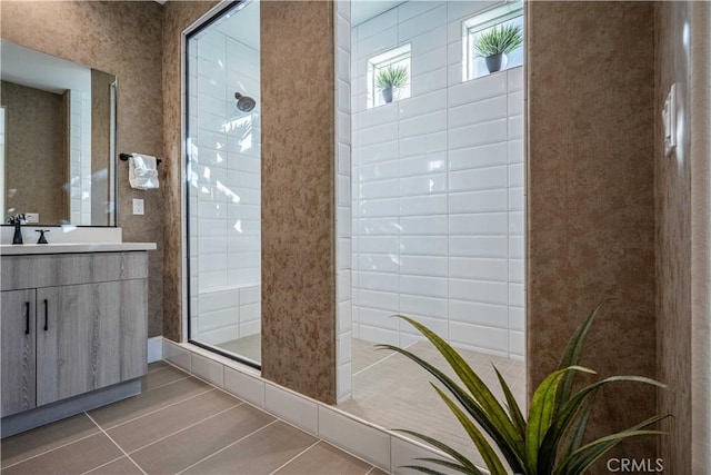 bathroom featuring vanity, tile patterned floors, and walk in shower